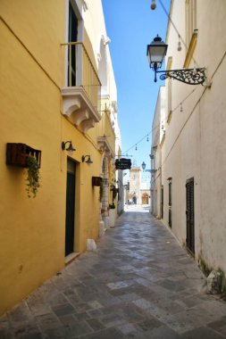 A narrow street between the old houses of Uggiano, a medieval town in the Puglia region of Italy.
