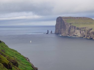 Bulutlu bir günde okyanus kıyısındaki yüksek dağlar