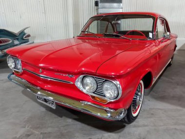 Avellaneda, Arjantin - 7 Mayıs 2022: Eski kırmızı Chevrolet Chevy Corvair Monza Coupe 1963 bir depoda. Expo Fierro 2022 klasik araba şovu. Kopyalama alanı.