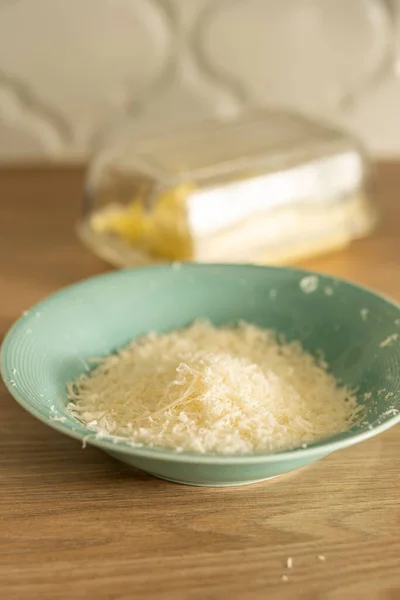 Tiro Vertical Queijo Parmigiano Reggiano Ralado Uma Tigela Uma Mesa — Fotografia de Stock