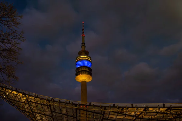 Eine Flache Aufnahme Des Münchner Olympiaturms Beleuchtet Mit Den Nationalfarben — Stockfoto