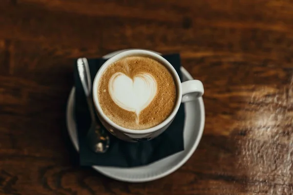 Una máquina de café que vierte capuchino en tazas