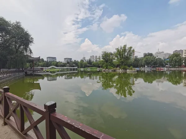 一个美丽的城市风景的照片 桥和绿色反映在湖中 — 图库照片