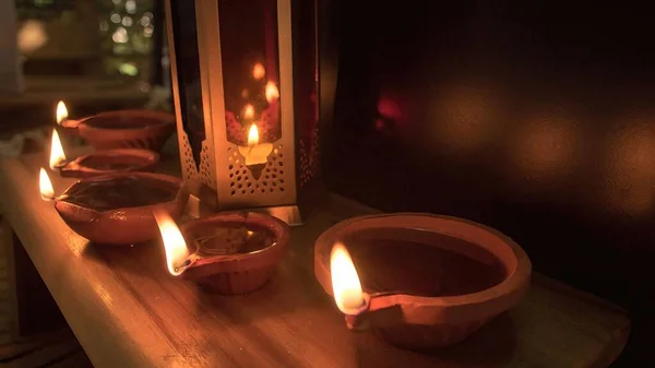 Diya lamp and oil lamp with fire and candles and color on dark background for celebration of Diwali festival of light