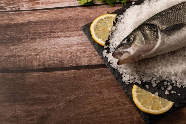 Fresh Whole Sea Bass Baked Salt Lemons Black Board — Fotografia de Stock