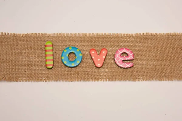 Palavra Amor Azulejos Coloridos Carta Colocada Pano Juta Hessian Isolado — Fotografia de Stock