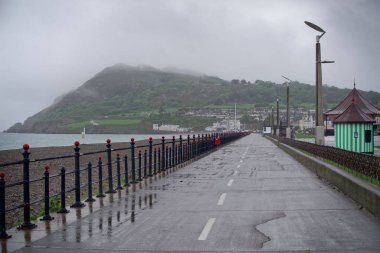 Bray Promenade, empty in the rain. The Bray Head mountain visible on the horizon is covered in fog. Typical Irish weather. clipart