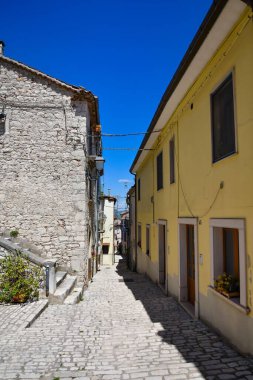 İtalya 'nın Molise bölgesindeki Sepino Ortaçağ köyünde güneşli bir havada dar bir sokak.