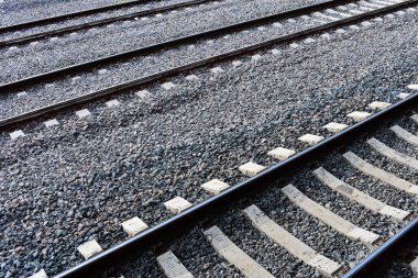 Gri çakıl üzerinde yüksek açılı tren yolu görüntüsü.