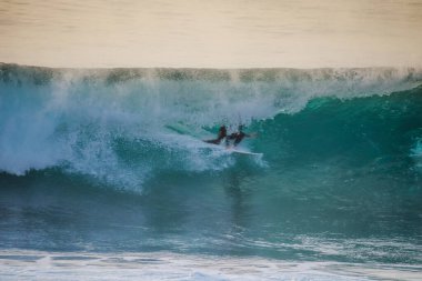Ericeira Portekiz 'de mükemmel bir varil dalgasında sörfçü.
