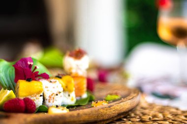 Bulanık arka planda bir bardak şampanyayla suşi rulolarının seçici odak noktası.