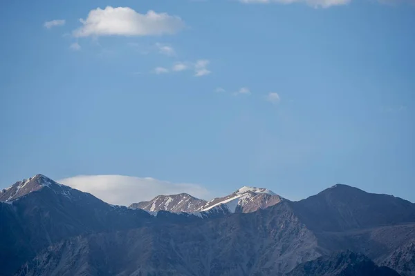 地平線に青空が広がる雪に覆われた高い山の峰 — ストック写真