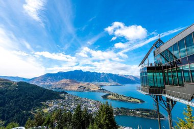 Güneşli bir günde Queenstown, Güney Adası, Yeni Zelanda 'da bir su kütlesi ve tatil köyü manzarası