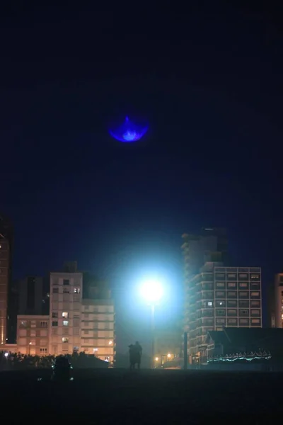 Вертикальный Снимок Ночной Панорамы Зданий Людей Идущих — стоковое фото