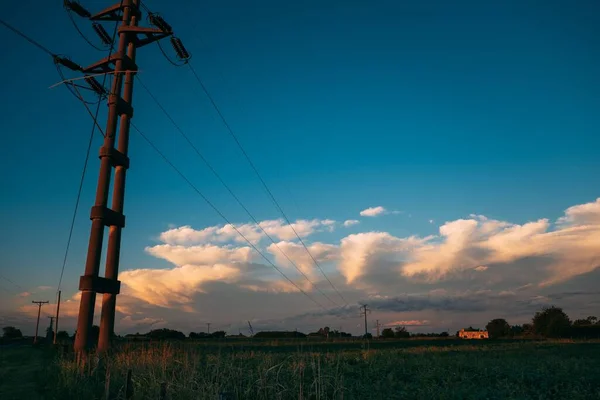 日没時に農村部の電力塔の低角度ショット — ストック写真