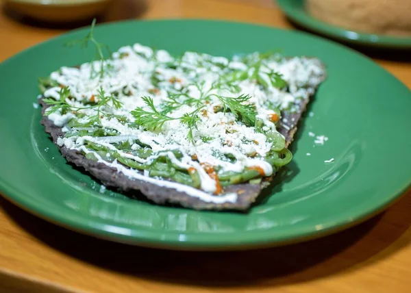沙司一种特色菜片的特写镜头 用香菜 奶酪和酸奶油加在绿色盘子上 — 图库照片