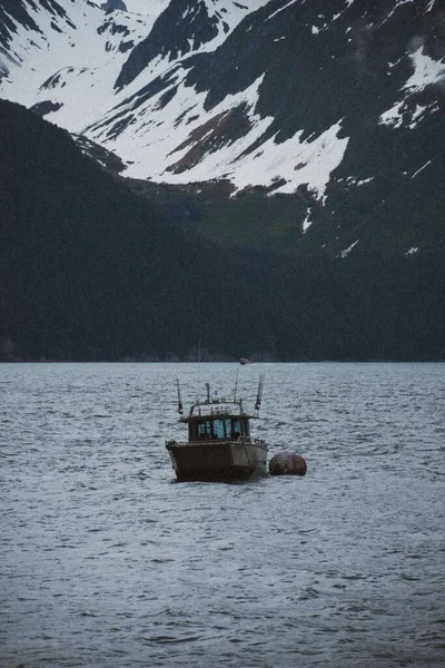 Μια Θέα Του Χιονισμένου Βουνού Και Μια Βάρκα Στο Νερό — Φωτογραφία Αρχείου