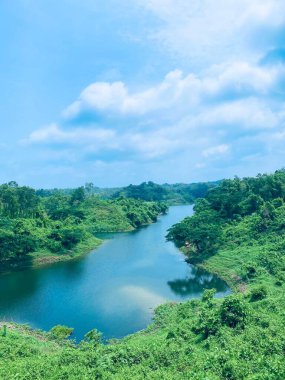 Yazın yansımaları olan güzel bir göl. Arka planda mavi gökyüzü.