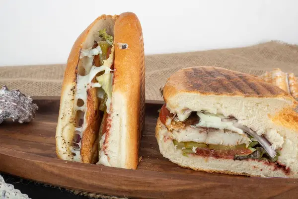 薄片烤三明治在木制盘子里放柠檬和辣椒的切片烤三明治 — 图库照片