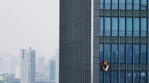 Trabalhador Com Uniforme Vermelho Limpando Janelas Enorme Edifício Financeiro Vidro — Fotografia de Stock