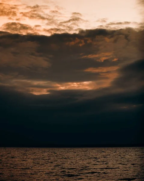 Tiro Vertical Oceano Durante Pôr Sol Vibrante Fundo Céu Nublado — Fotografia de Stock