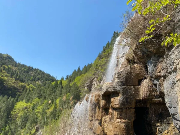 Una Pequeña Cascada Rodeada Árboles Siempreverdes Rocas Contra Cielo Azul —  Fotos de Stock