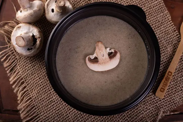 一个顶部拍摄的蘑菇奶油汤在一个黑色碗 — 图库照片