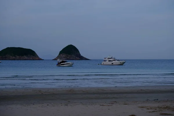 在蓝色的大海中 在沙滩上航行的船只与绿色岛屿相映成趣 — 图库照片