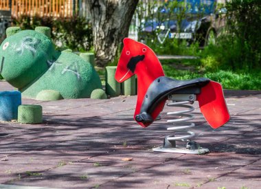 Çeşitli oyuncakları olan renkli bir oyun alanı ekipmanı. Güneşli bir günde bahar binicisi de dahil.