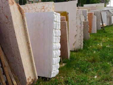 Çimlerin üzerinde birbirine yaslanan farklı taş bloklardan oluşan bir kare.