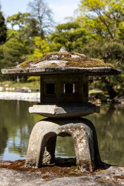Japon bahçesinin etrafına yerleştirilmiş taş bir heykel