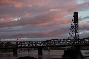 Günbatımında suyun üzerindeki modern bir köprünün alçak açılı görüntüsü