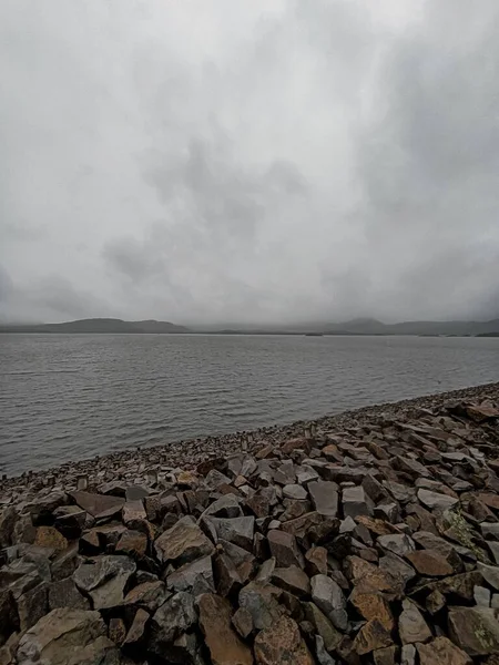Lovitură Verticală Unui Lac Coastă Stâncoasă Cer Tulbure — Fotografie, imagine de stoc