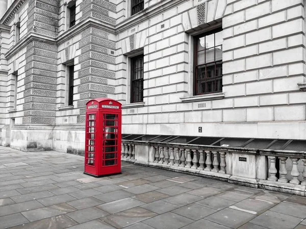 A selective color shot of a traditional red phone booth in London, UK