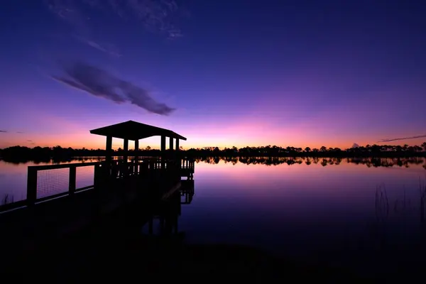 Silhouette Pier Sea Trees Line Other Side Sunset — Stock Photo, Image