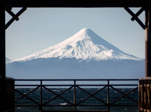 澄んだ空の下の木製デッキからの雪の山の美しい景色 — ストック写真