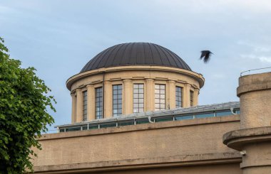 Wroclaw 'da mavi parlak gökyüzünün altında pencereleri olan yuvarlak taşlı bir binanın yakın çekimi.