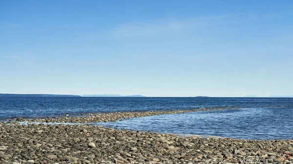 遠くの島々と岩のビーチからの波打つ深い青い海の眺め — ストック写真