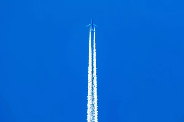 青い空にジェット飛行機の長い白い歩道の低角度ショット — ストック写真