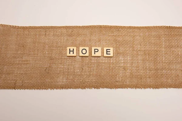 Έννοια Hope Πλακάκια Γραμμάτων Πάνω Ύφασμα Από Γιούτα Hessian Απομονωμένο — Φωτογραφία Αρχείου