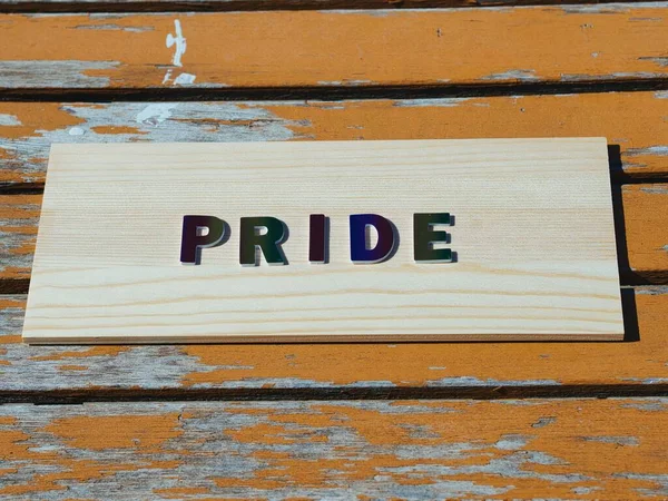 Palabra Orgullo Letras Arco Iris Una Mesa Madera Naranja Envejecida — Foto de Stock