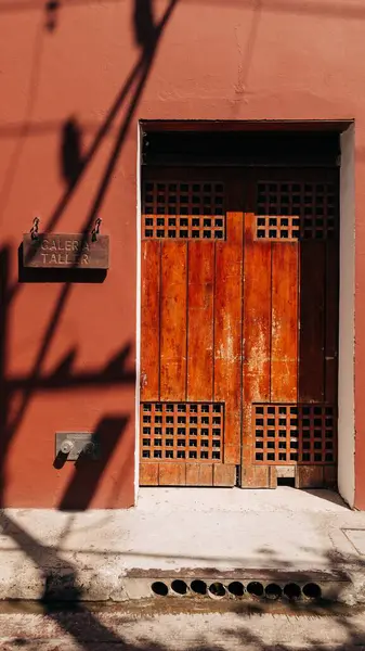 Вертикальный Снимок Старых Деревянных Дверей Темно Оранжевой Каменной Стене — стоковое фото