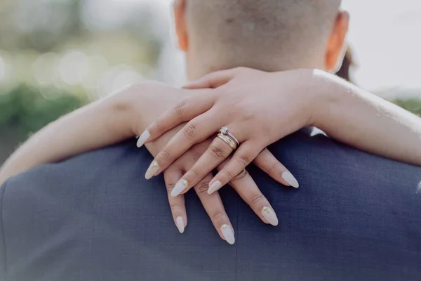Zbliżenie Kobiecych Rąk Obrączką Małżeńską Przywiązaną Szyi Mężczyzny — Zdjęcie stockowe