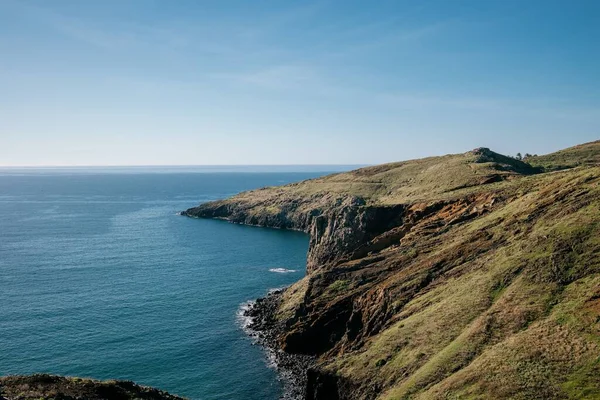 Bulutlu Arka Planda Tepelerle Çevrili Mavi Bir Deniz Manzarası — Stok fotoğraf