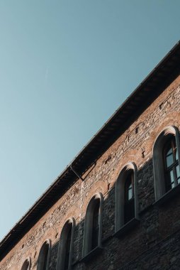 Mavi gökyüzüne karşı kemerli eski bir binanın dikey alçak açılı görüntüsü..