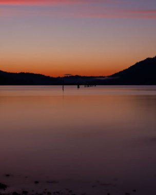 Dağların üzerinde büyüleyici bir altın gün batımı manzarası