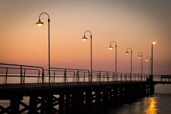 Eine Strandpromenade Auf Dem Wasser Mit Lichtern Bei Sonnenuntergang — Stockfoto