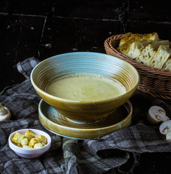 テーブルクロスにパンのバスケットとエンドウ豆のスープの閉鎖 — ストック写真