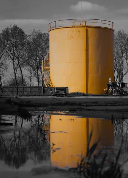 Een Grijsschaal Shot Van Opslagtanks Voor Aardolieproducten Met Gele Elementen — Stockfoto