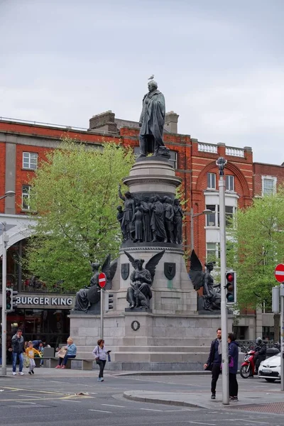 位于都柏林的雕塑家约翰 John Henry Foley 对奥康奈尔纪念碑的垂直拍摄 浅灰底座上有天使 女人和男人雕像的黑色雕像 — 图库照片